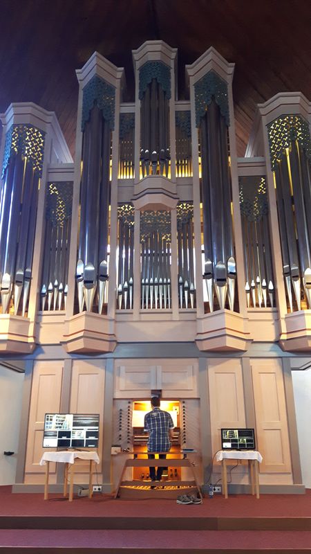 Herr Feyrer spielt an der Orgel. Er wirkt winzig vor dem riesigen Instrument.