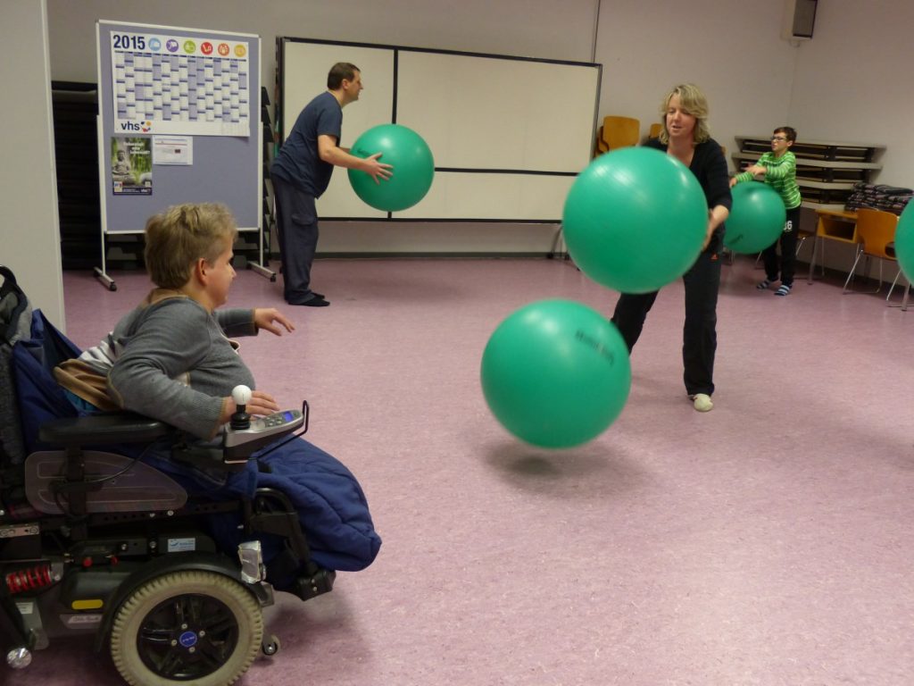Kurs·teilnehmer spielen mit Gymnastik·bällen