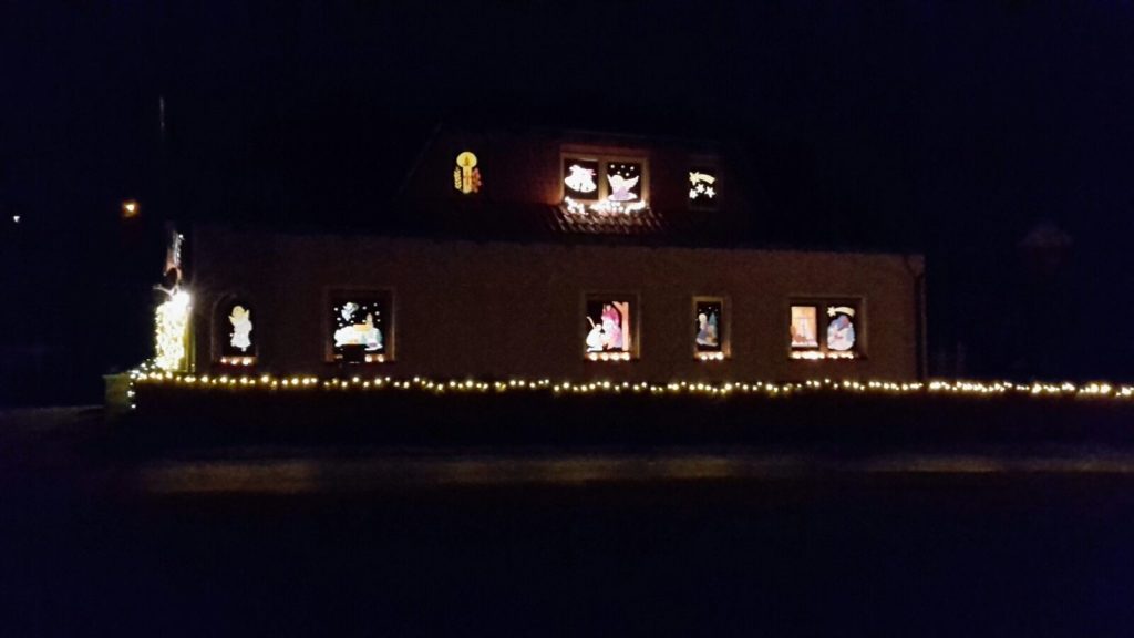 Hell erleuchtete, mit Weihnachtsmotiven dekorierte Fenster